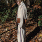 A woman walking her dog in the woods with a Mellow Pet Store Woolen Dog Vest - White.